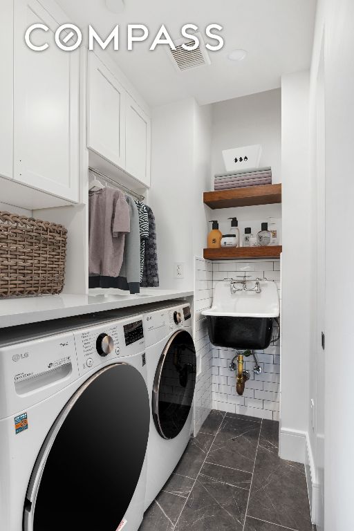 laundry room with cabinets, sink, and washing machine and dryer