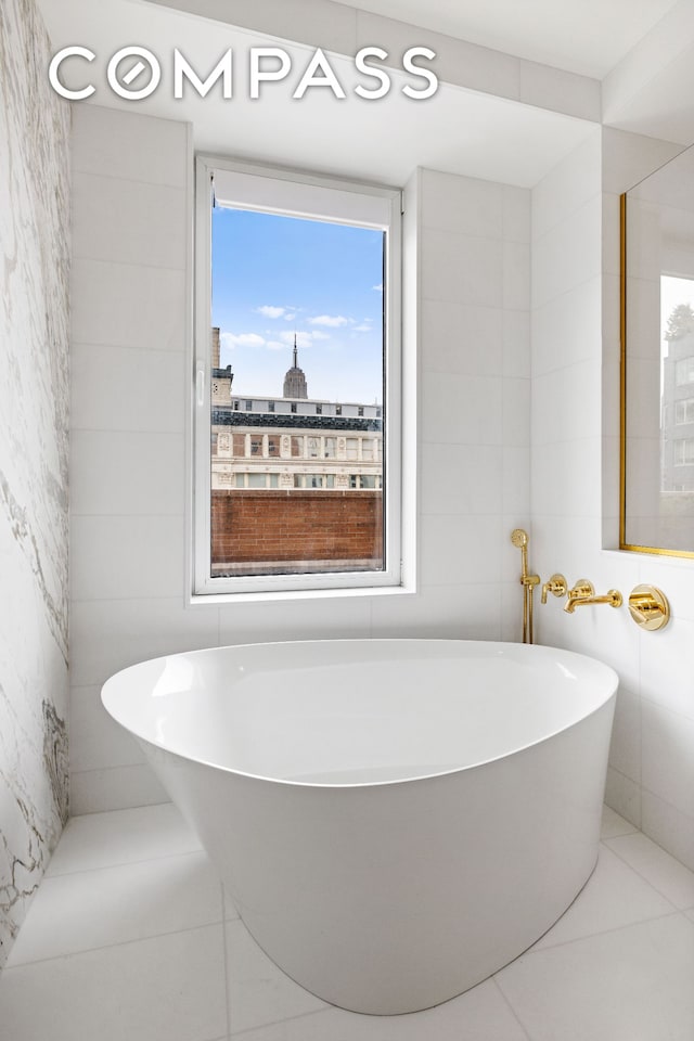 full bathroom featuring a soaking tub and tile walls