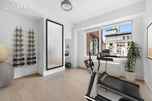 workout room featuring wood finished floors and baseboards