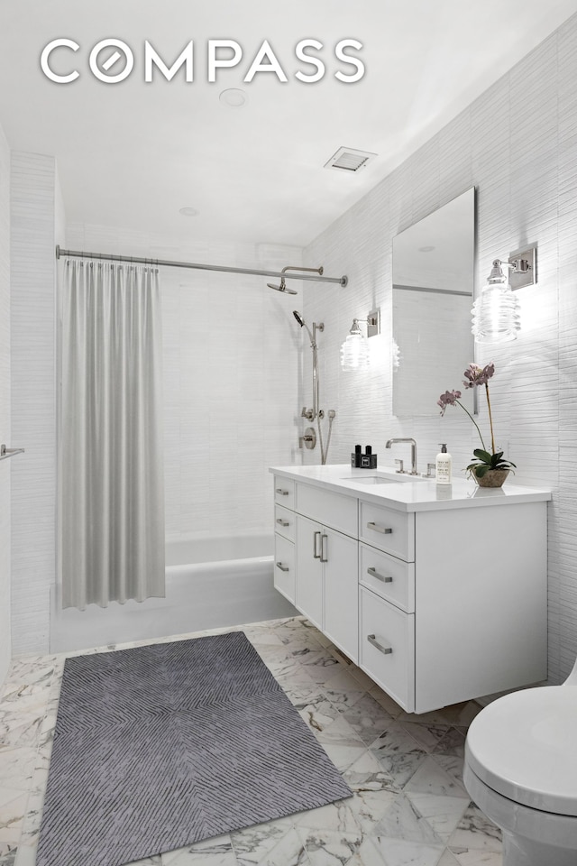 full bath featuring tile walls, toilet, shower / bath combo, marble finish floor, and vanity