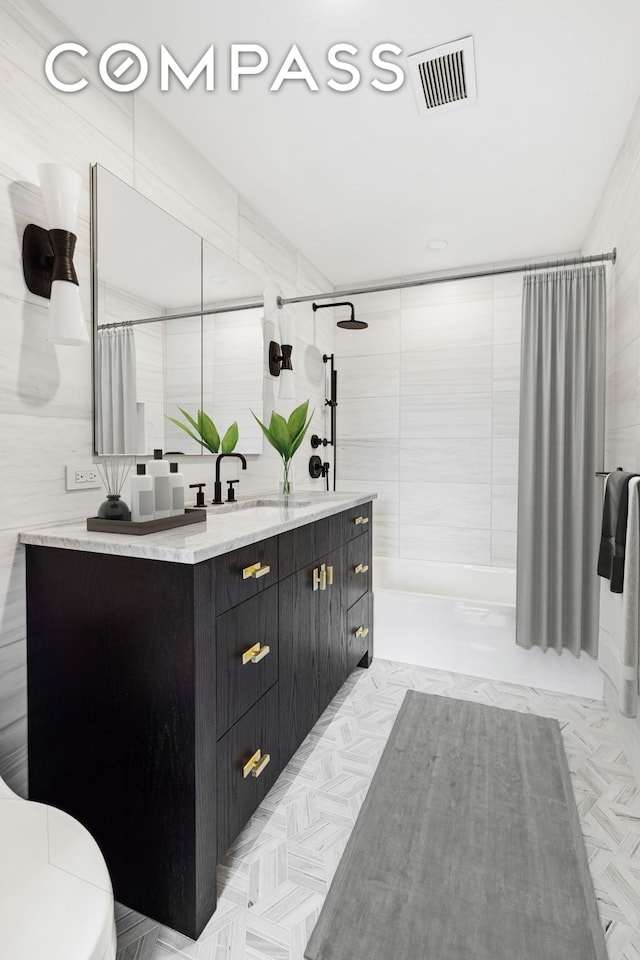 bathroom featuring visible vents, tiled shower, toilet, and vanity