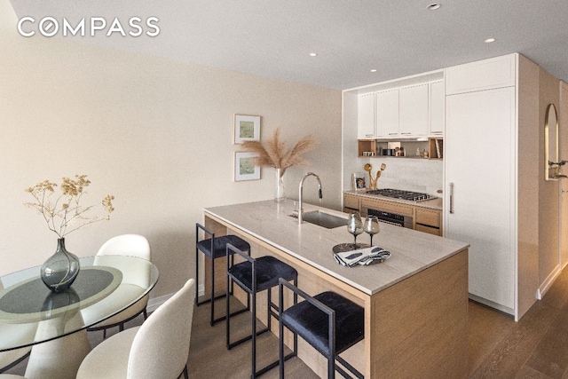 kitchen featuring white cabinetry, stainless steel appliances, dark wood-type flooring, and sink