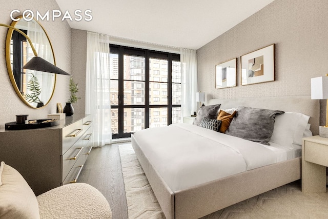 bedroom featuring light wood-style flooring and wallpapered walls