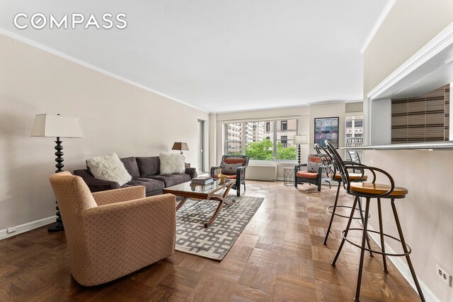 living room with ornamental molding and parquet floors