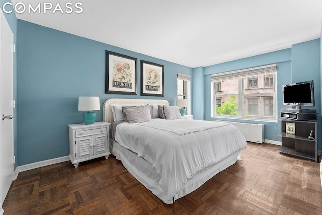 bedroom with dark parquet flooring and radiator