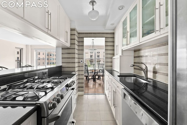 kitchen featuring white cabinetry, light tile patterned flooring, stainless steel gas stove, dishwasher, and sink