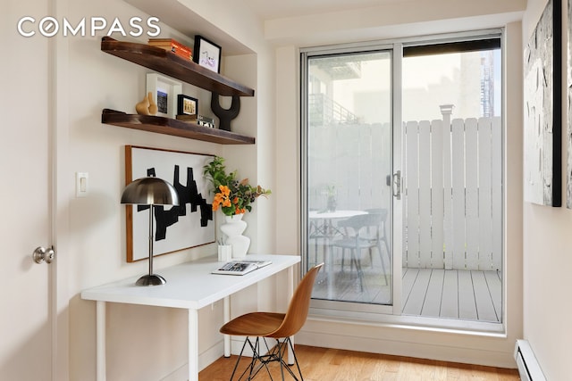 doorway with a baseboard heating unit and light wood-type flooring