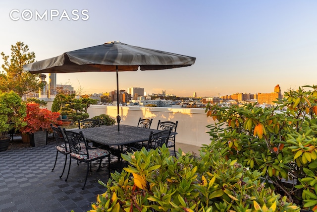 patio terrace at dusk featuring a city view and outdoor dining space