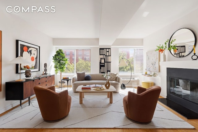 living room with a wall mounted AC and light hardwood / wood-style floors