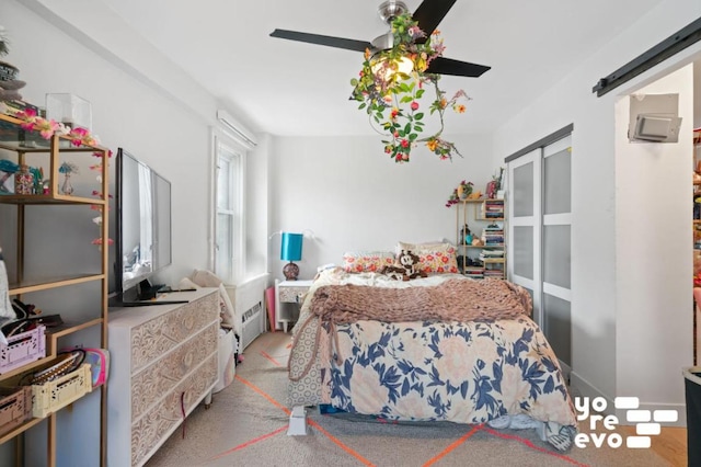 bedroom with a barn door and ceiling fan