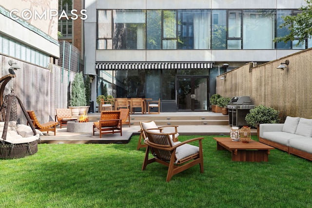 rear view of house with an outdoor living space with a fire pit, a lawn, and a patio