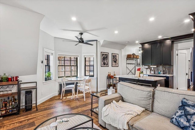 living room with dark hardwood / wood-style flooring and ceiling fan