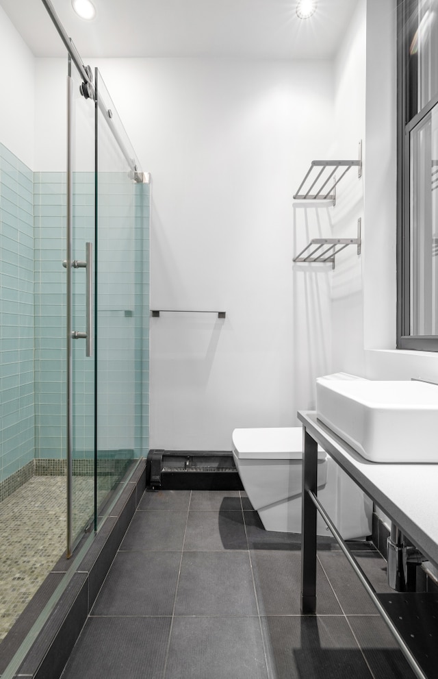 bathroom with a stall shower, a sink, toilet, and recessed lighting