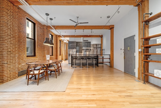 dining area featuring brick wall, ceiling fan, and wood finished floors