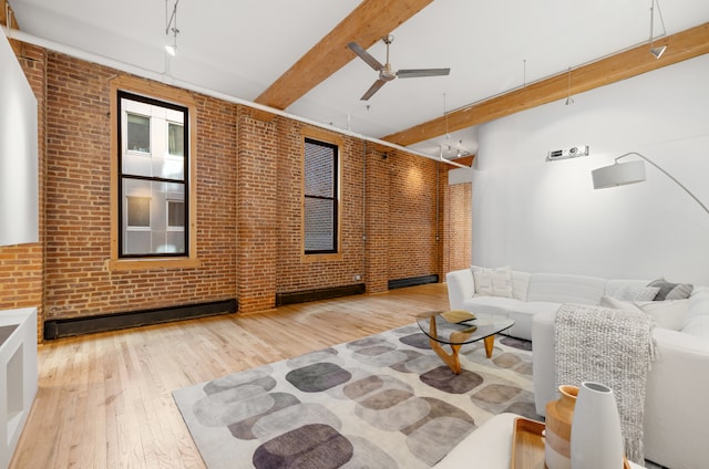 living room with beam ceiling, a baseboard radiator, ceiling fan, brick wall, and wood finished floors