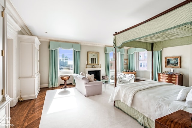 bedroom featuring multiple windows, dark hardwood / wood-style floors, and crown molding