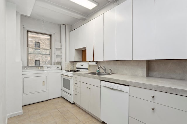 kitchen featuring white appliances, white cabinets, light countertops, washing machine and dryer, and a sink