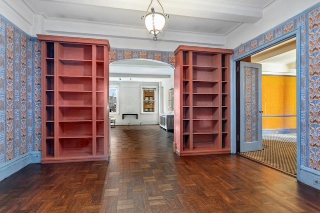 corridor with radiator, dark parquet flooring, and ornamental molding