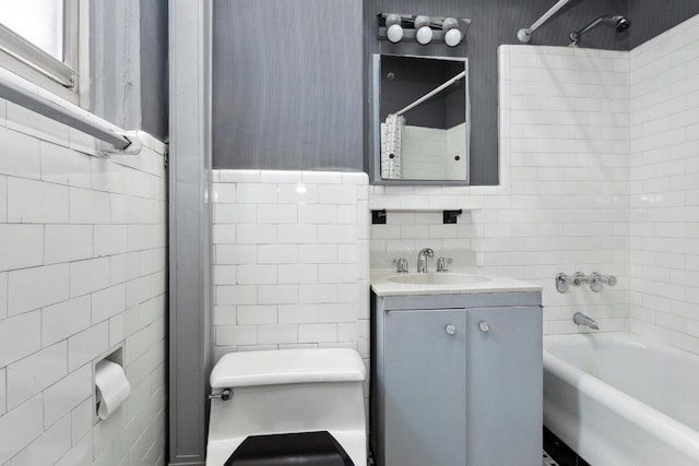 full bathroom with shower / washtub combination, toilet, tile walls, and vanity