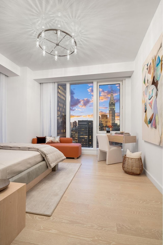 bedroom with an inviting chandelier, wood finished floors, and baseboards