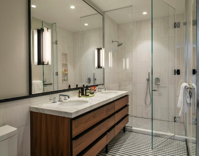 bathroom with toilet, tile walls, a shower with shower door, and vanity