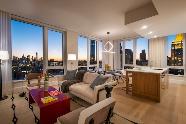 living room featuring a view of city, light wood-style flooring, and a wall of windows