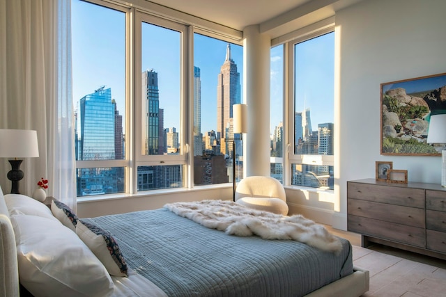 bedroom featuring a city view and wood finished floors