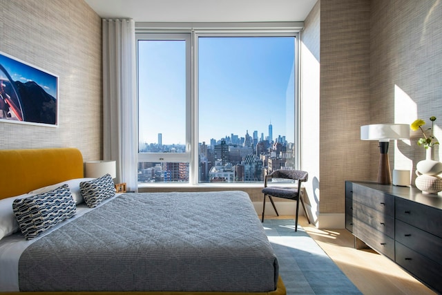 bedroom with a view of city and floor to ceiling windows