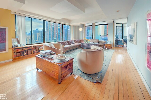 living room featuring floor to ceiling windows, a wealth of natural light, and light hardwood / wood-style floors