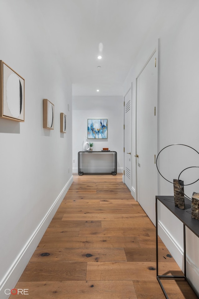 hallway with recessed lighting, wood-type flooring, and baseboards