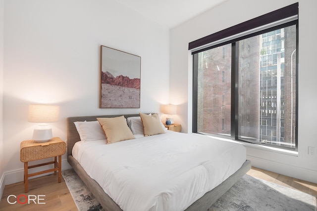 bedroom featuring wood finished floors and baseboards