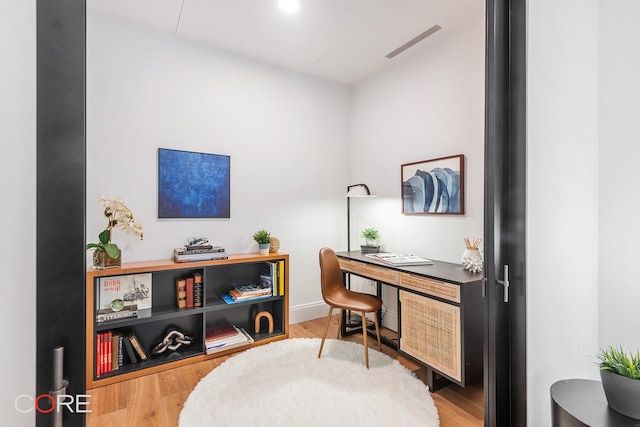 office area with visible vents, baseboards, and wood finished floors