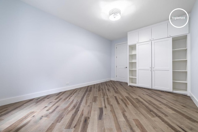 unfurnished bedroom featuring light wood finished floors and baseboards