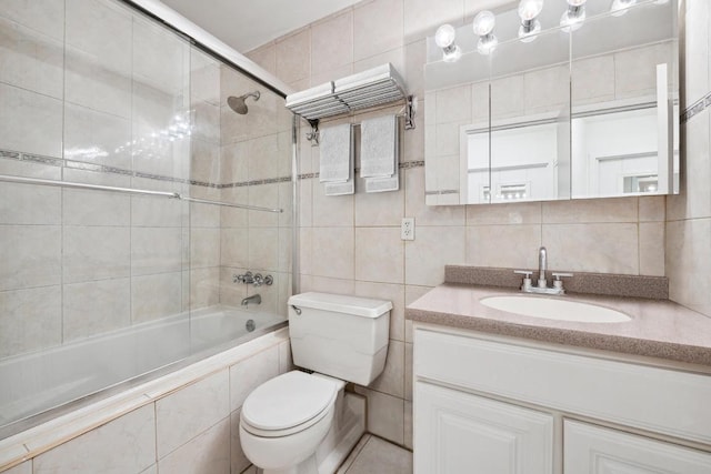 full bathroom featuring toilet, tile walls, vanity, enclosed tub / shower combo, and decorative backsplash