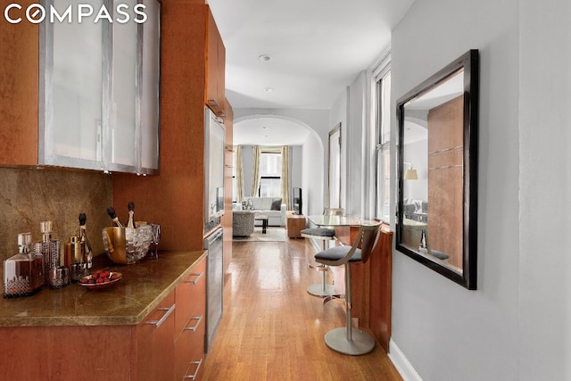 bar featuring backsplash and light hardwood / wood-style floors