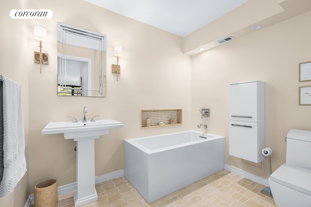 bathroom with toilet, tile patterned floors, and a tub to relax in