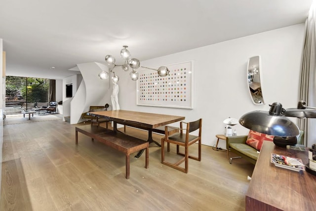 dining room featuring expansive windows, light hardwood / wood-style flooring, and a notable chandelier