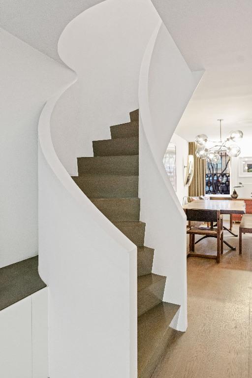 stairs featuring a chandelier