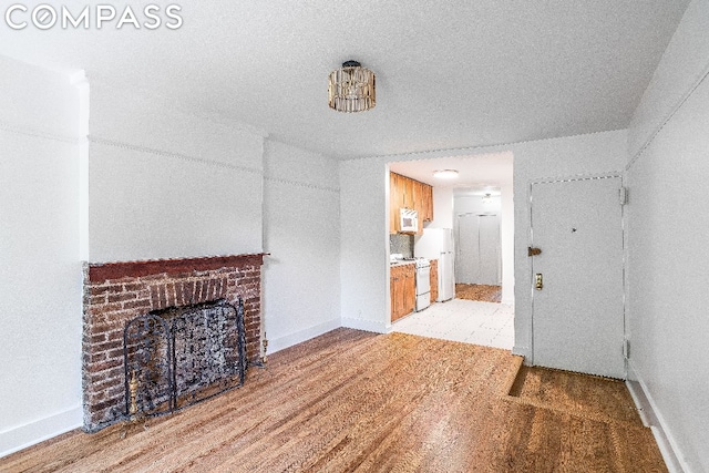 unfurnished living room featuring a brick fireplace and light hardwood / wood-style floors