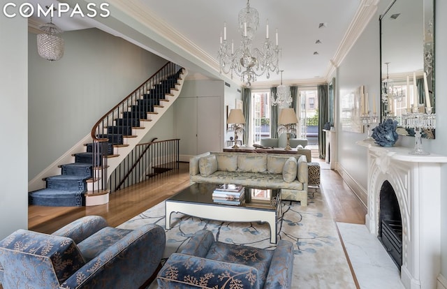 living room with ornamental molding, a chandelier, and light wood-type flooring