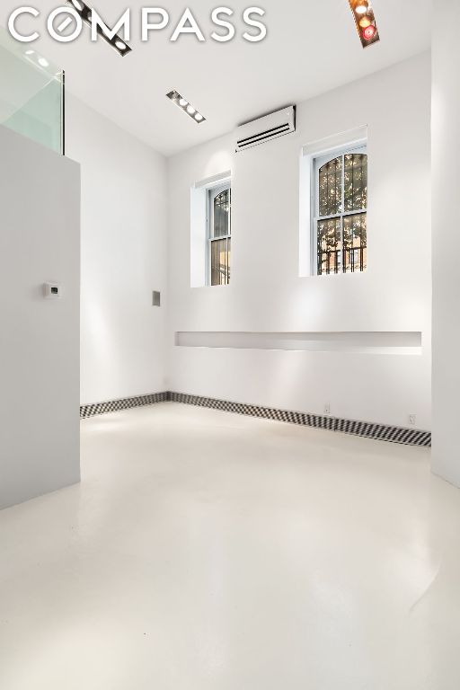 empty room with concrete flooring and a wall unit AC