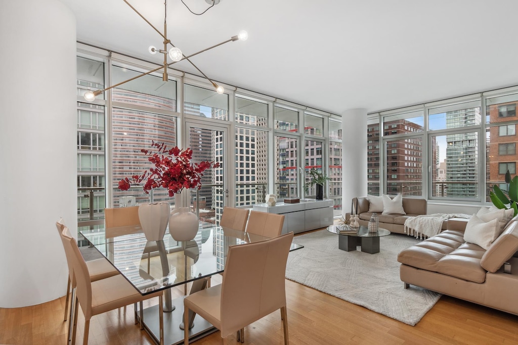 dining area featuring floor to ceiling windows, a view of city, and wood finished floors