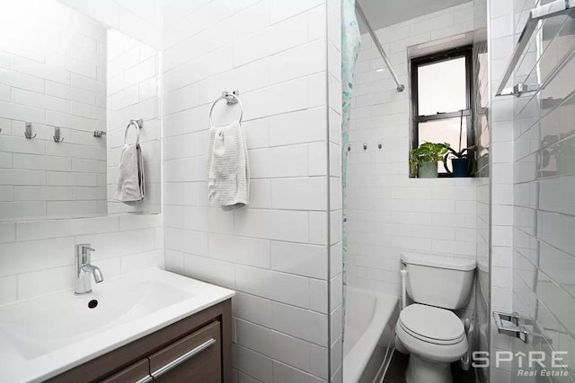 full bathroom with vanity, tiled shower / bath, tile walls, and toilet