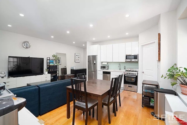 dining space featuring light wood-style flooring, a toaster, and recessed lighting