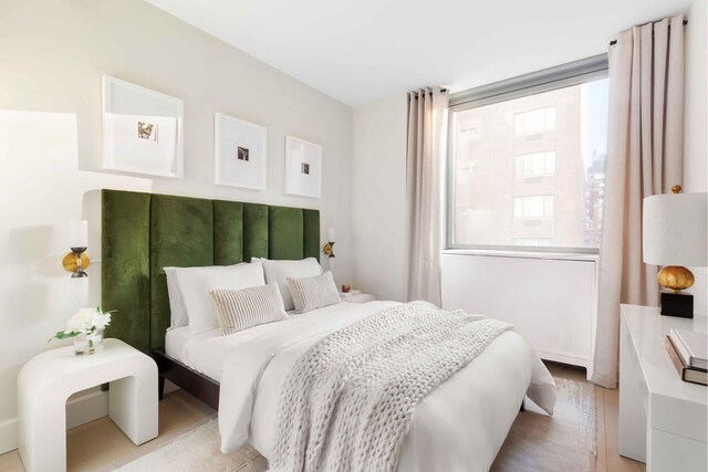 bedroom featuring multiple windows and light wood finished floors