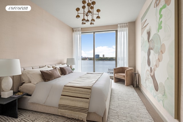 bedroom with visible vents, a water view, a notable chandelier, wood finished floors, and access to exterior