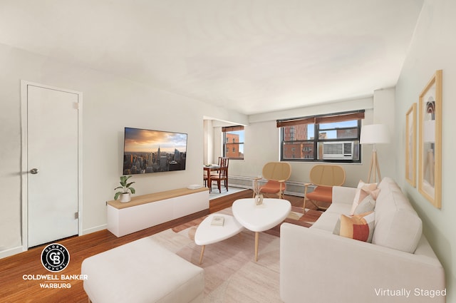 living area with cooling unit, baseboards, and wood finished floors