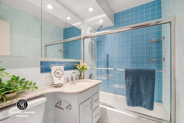 full bathroom with toilet, recessed lighting, shower / bath combination with glass door, tile walls, and vanity