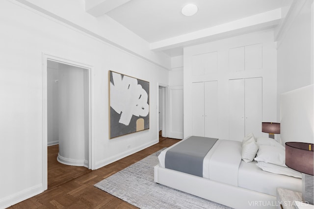 bedroom with two closets, beam ceiling, and baseboards