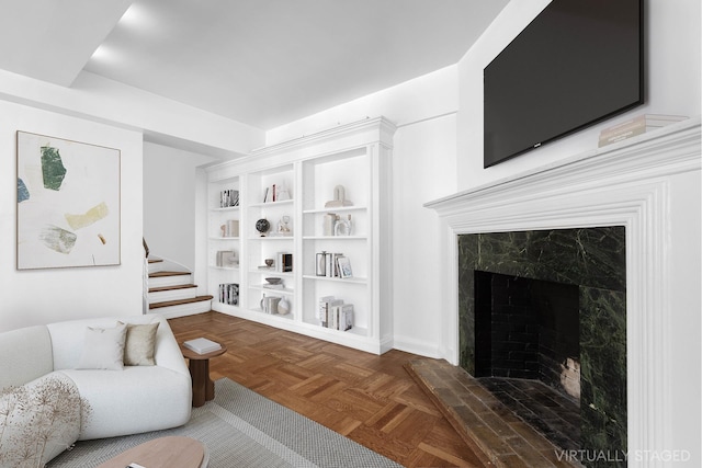 living area featuring a high end fireplace and stairs